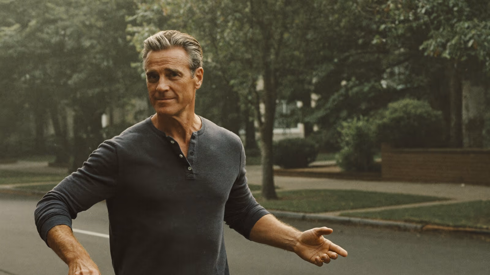 A man walking on a quiet tree-lined street in the morning